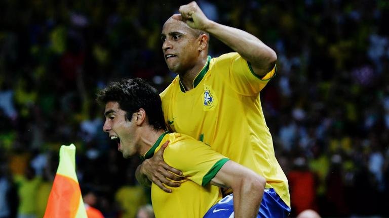 BERLIN - JUNE 13: Kaka of Brazil celebrates scoring the opening goal with team mate Roberto Carlos (R) during the FIFA World Cup Germany 2006 Group F match between Brazil and Croatia played at the Olympic Stadium on June 13, 2006 in Berlin, Germany. (Photo by Alex Livesey/Getty Images)