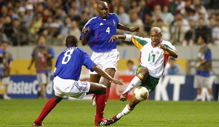 SEOUL - MAY 31:  El Hadji Diouf (No.11) of Senegal takes the ball round Marcel Desailly (No.8) of France during the France v Senegal Group A, World Cup Group Stage match played at the Seoul World Cup Stadium, Seoul, South Korea on May 31, 2002. Senegal won the match 1-0. (Photo by Shaun Botterill/Getty Images)