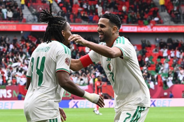 Algeria's midfielder #14 Hicham Boudaoui (L) and Algeria's forward #7 Riyad Mahrez celebrate the team's first goal during the Africa Cup of Nations (CAN) Group E football match between Algeria and Sudan at Moulay Hassan Stadium in Rabat on December 24, 2025. (Photo by SEBASTIEN BOZON / AFP via Getty Images)